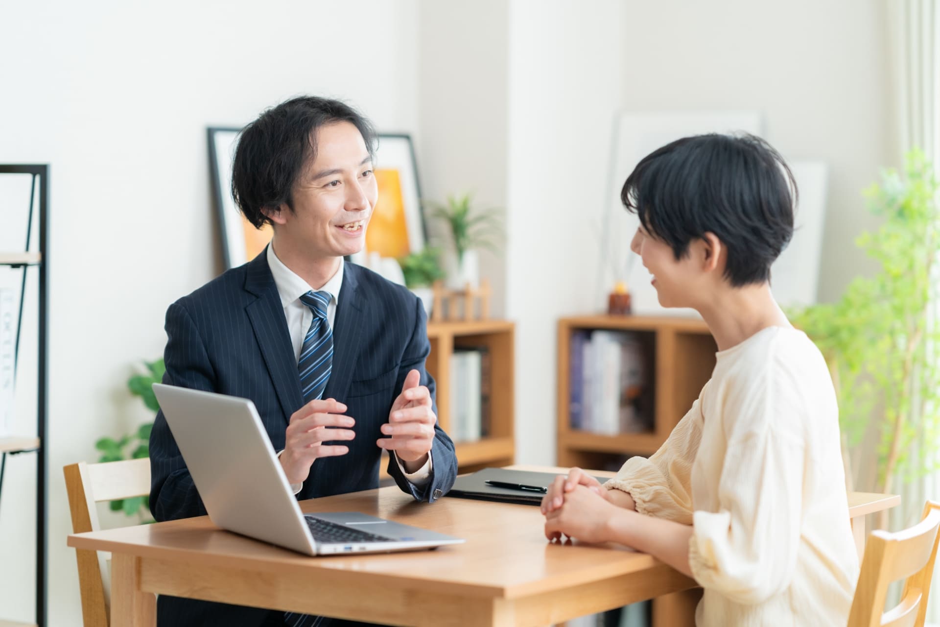 外壁塗装の目的を説明する営業マンとそれを聞く主婦のイメージ画像